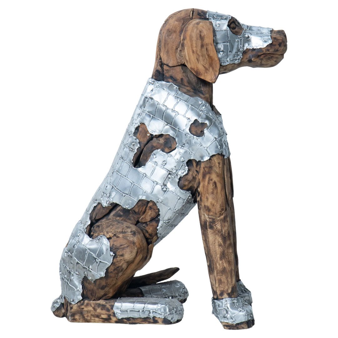 A decorative metal dog sculpture shown in profile against a plain white background. The sculpture features a silver-toned textured metal body with exposed brown wood-like sections.