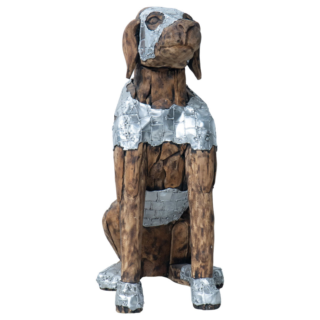 A decorative sculpture of a sitting dog made from brown wood with metallic silver painted armor-like details on the head, chest, and paws, shown against a plain white background.